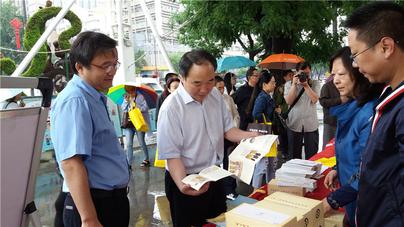 西安市档案局副局长吴立民(左二)、未央区副区长李亚省(左一)翻看宣传册.jpg 西安市档案局副局长吴立民(左二)、未央区副区长李亚省(左一)翻看宣传册.jpg